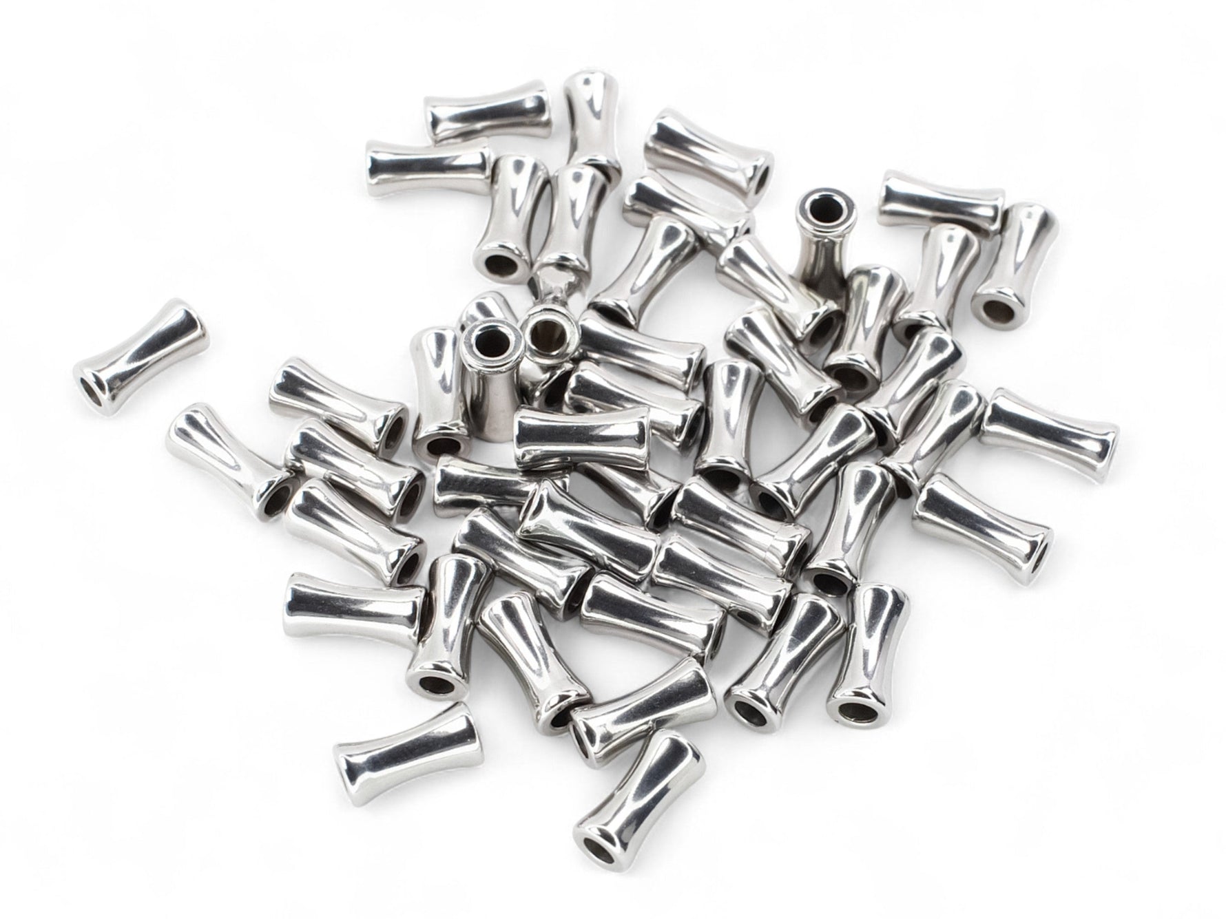 Silver plated alloy bamboo shaped spacer beads on a white surface