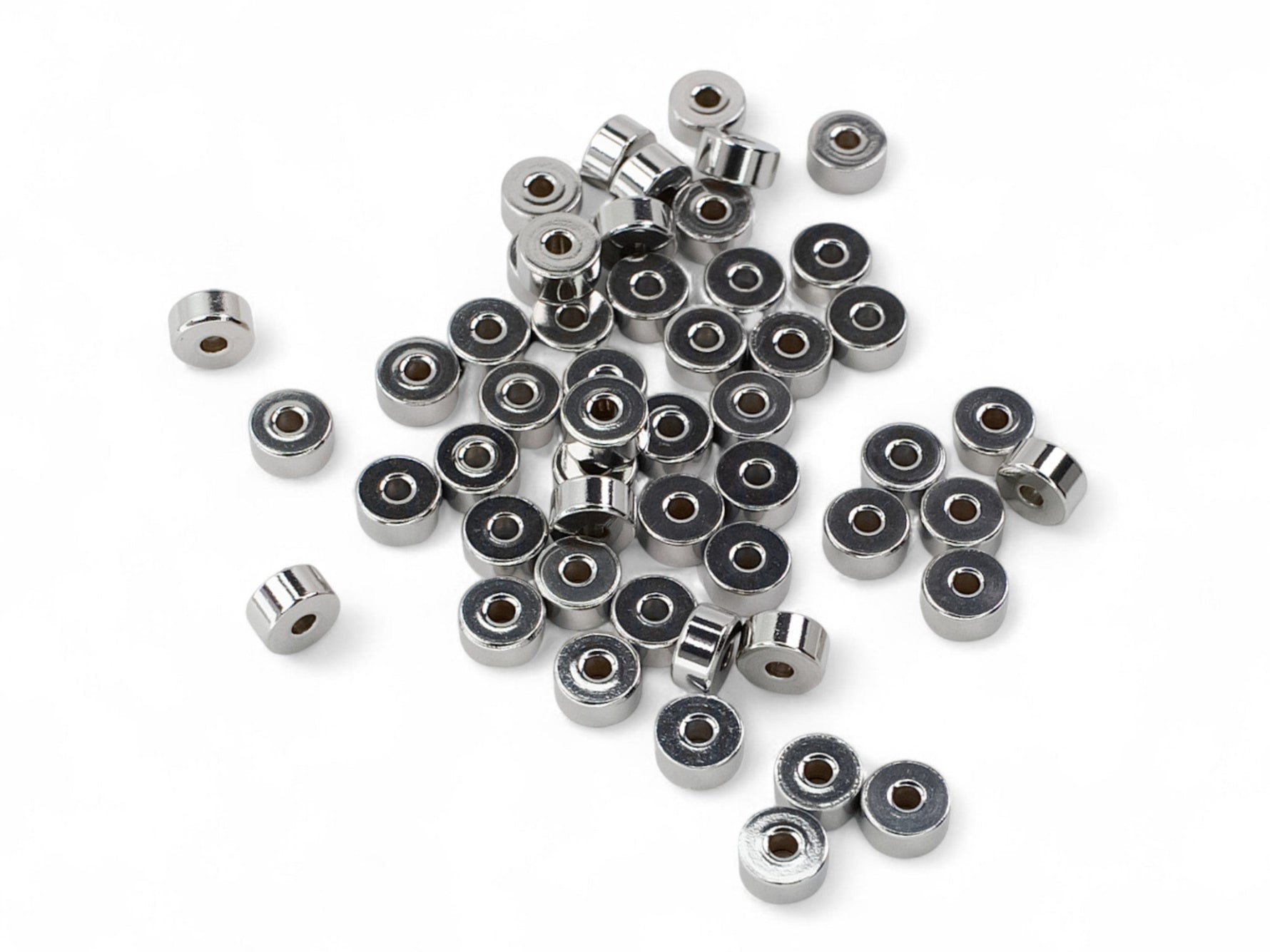Silver stainless steel disc heishi washer spacer beads on white surface