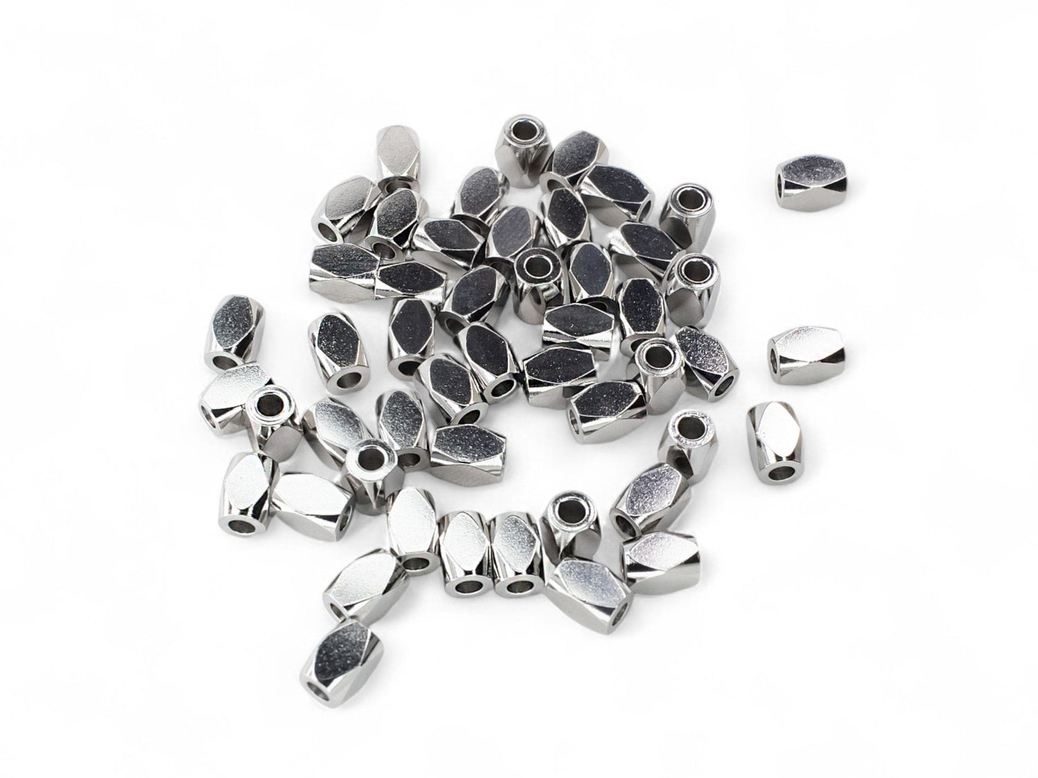 Diamond pattern barrel shaped silver stainless steel beads on a white background.