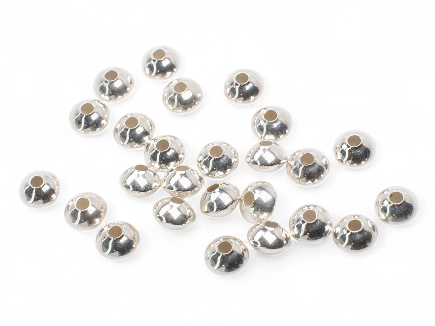 Saucer stainless steel spacer beads on a white background