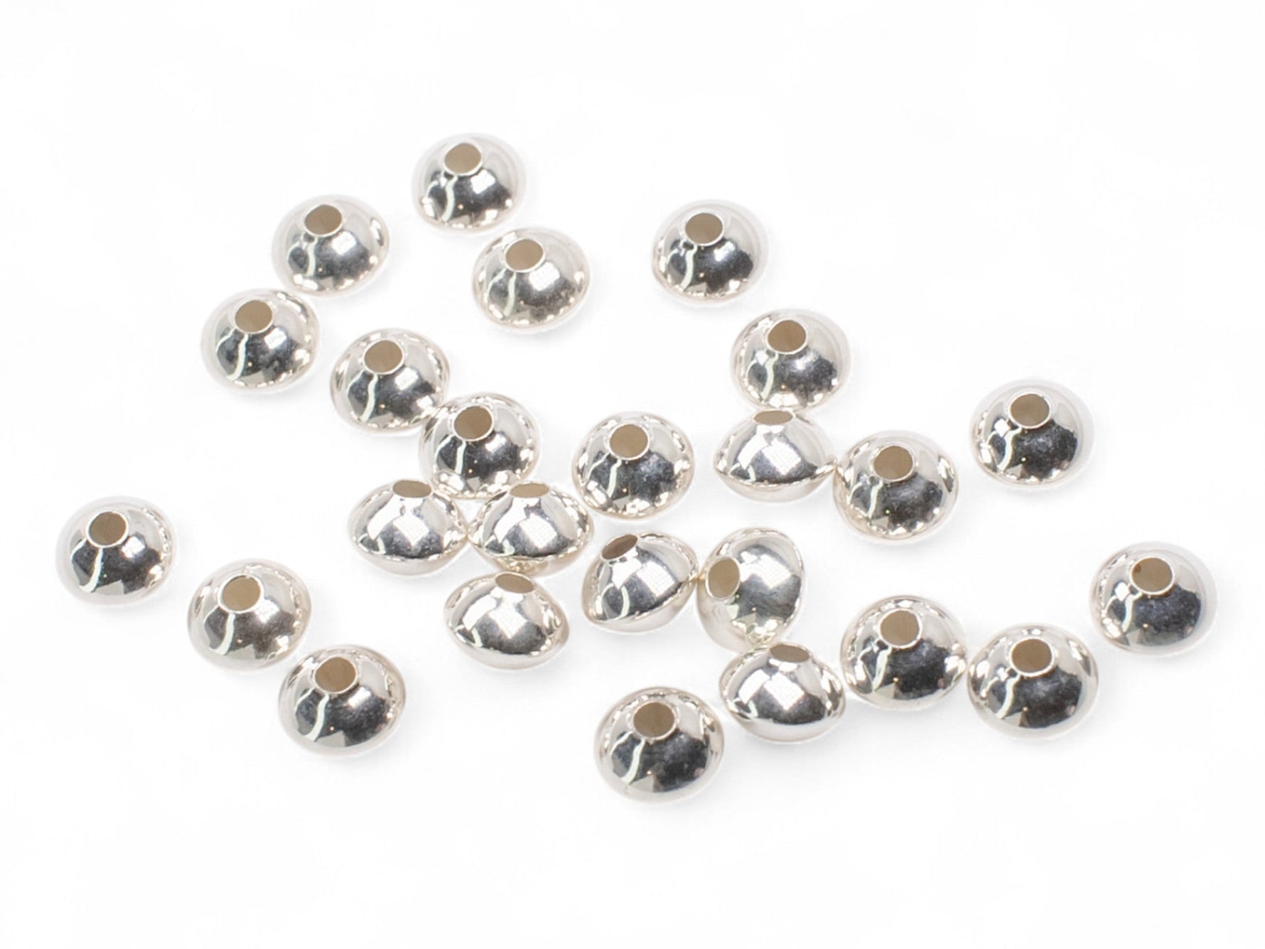 Saucer stainless steel spacer beads on a white background