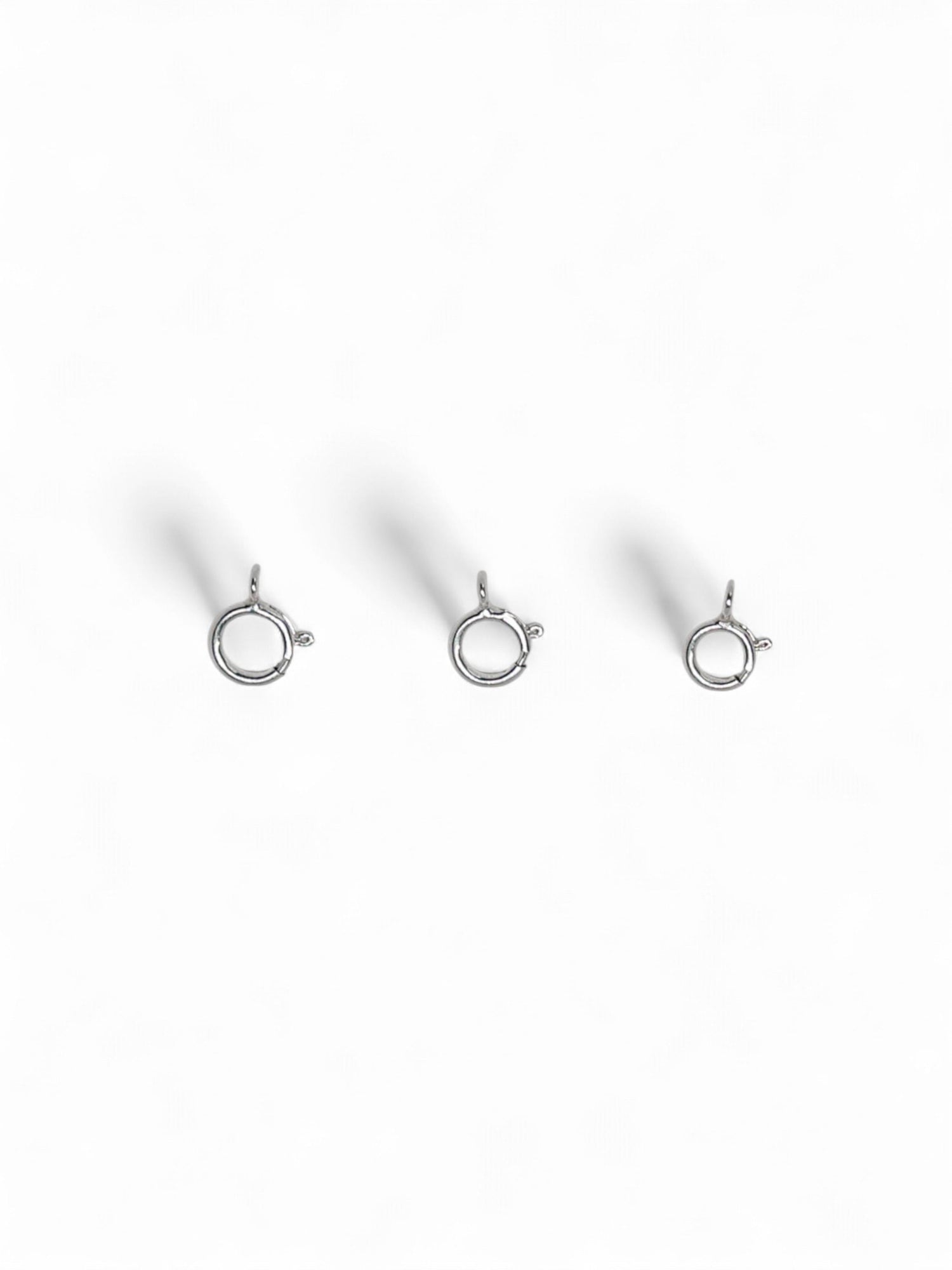 Three silver jewelry clasps on a white background