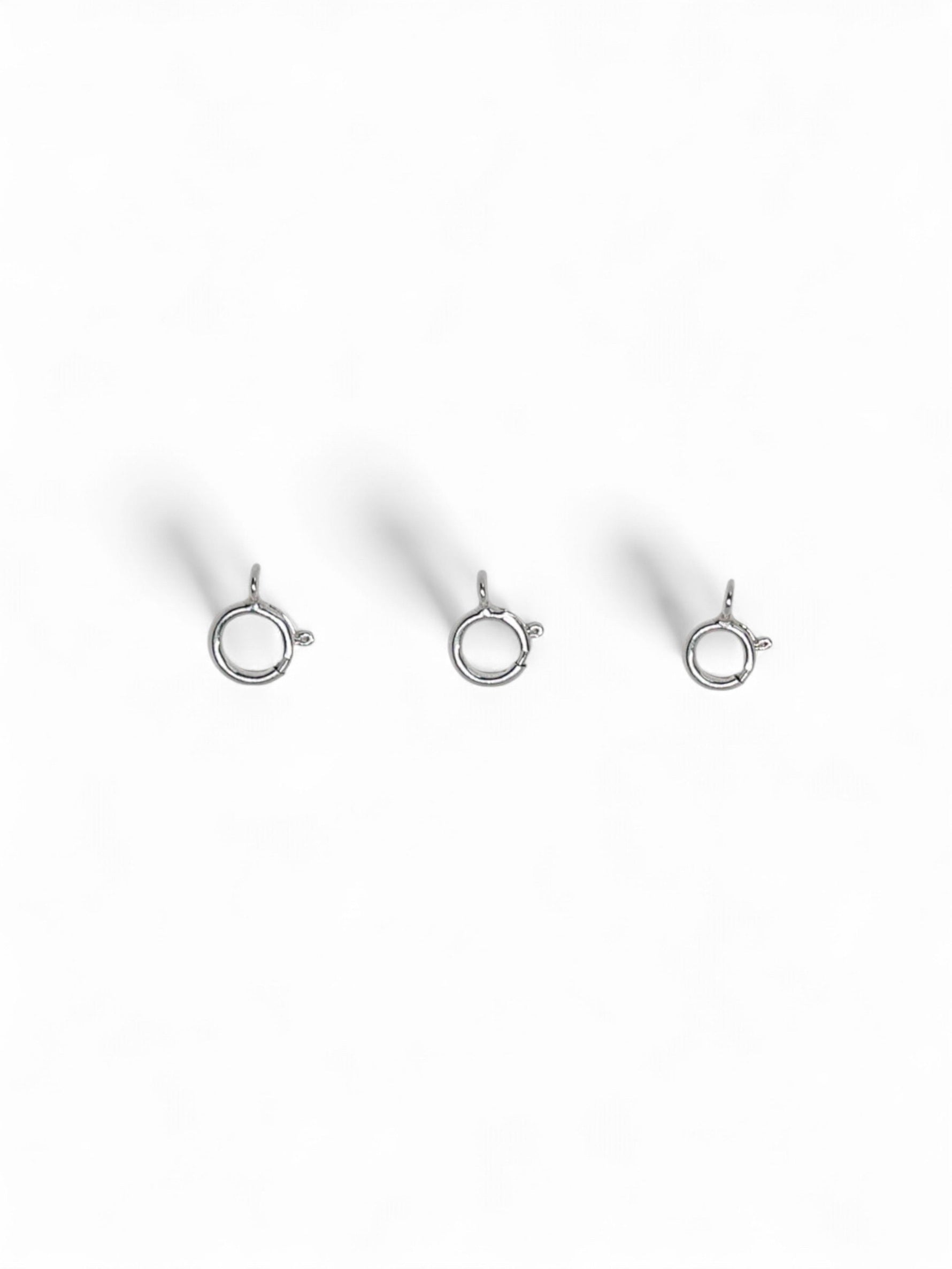 Three silver jewelry clasps on a white background