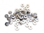 Collection of small silver spacer beads on a white background