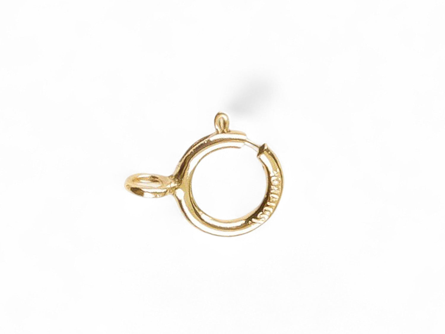 Gold open spring ring clasp on a white background
