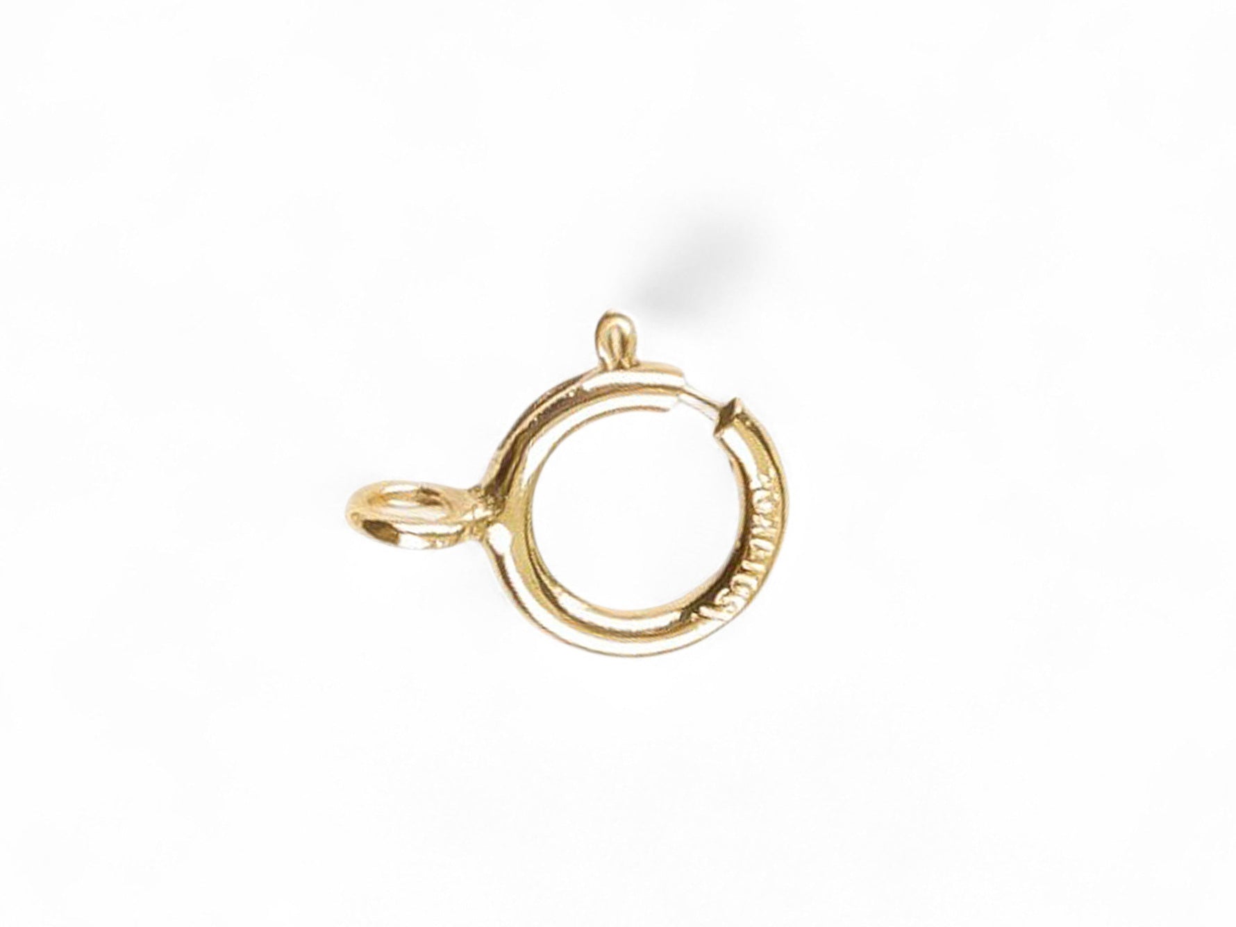 Gold open spring ring clasp on a white background