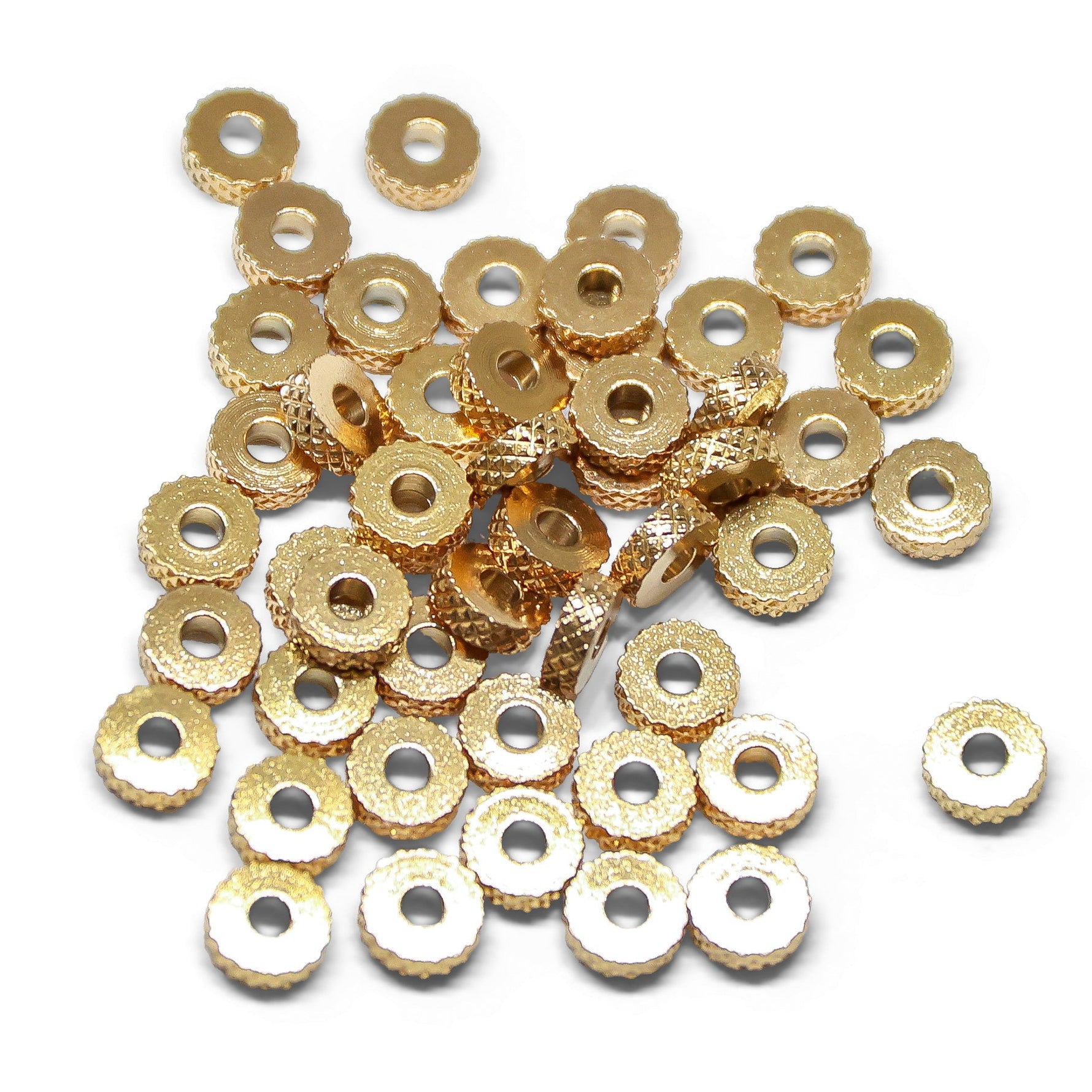 Gold metal washer-shaped beads on a white background
