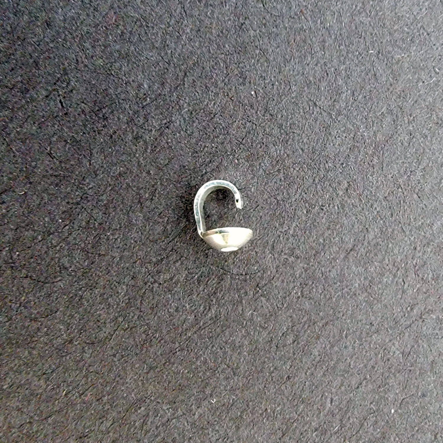 Small sterling silver bead cap on a dark gray background